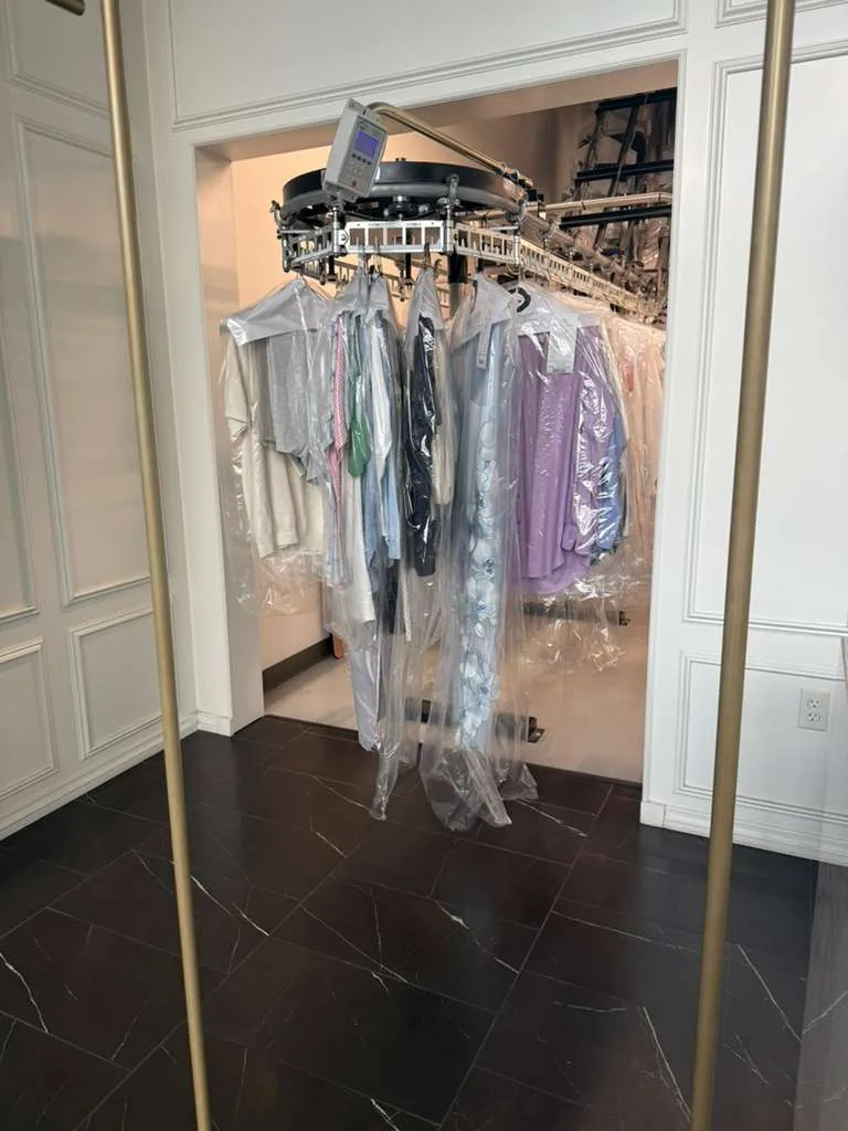 Finished garments protected and arranged on the conveyor inside Central Cleaners